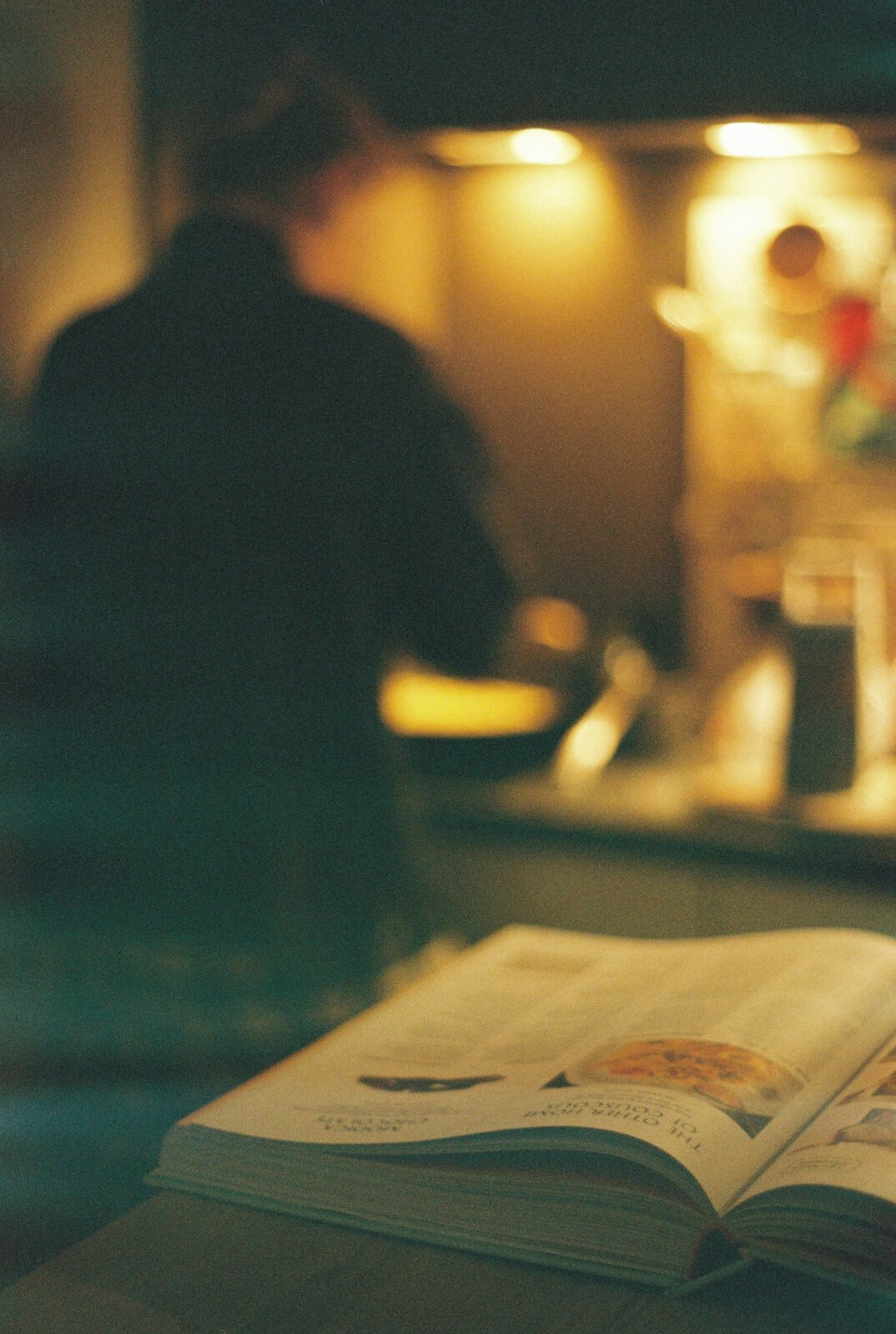 person reading book in dim light